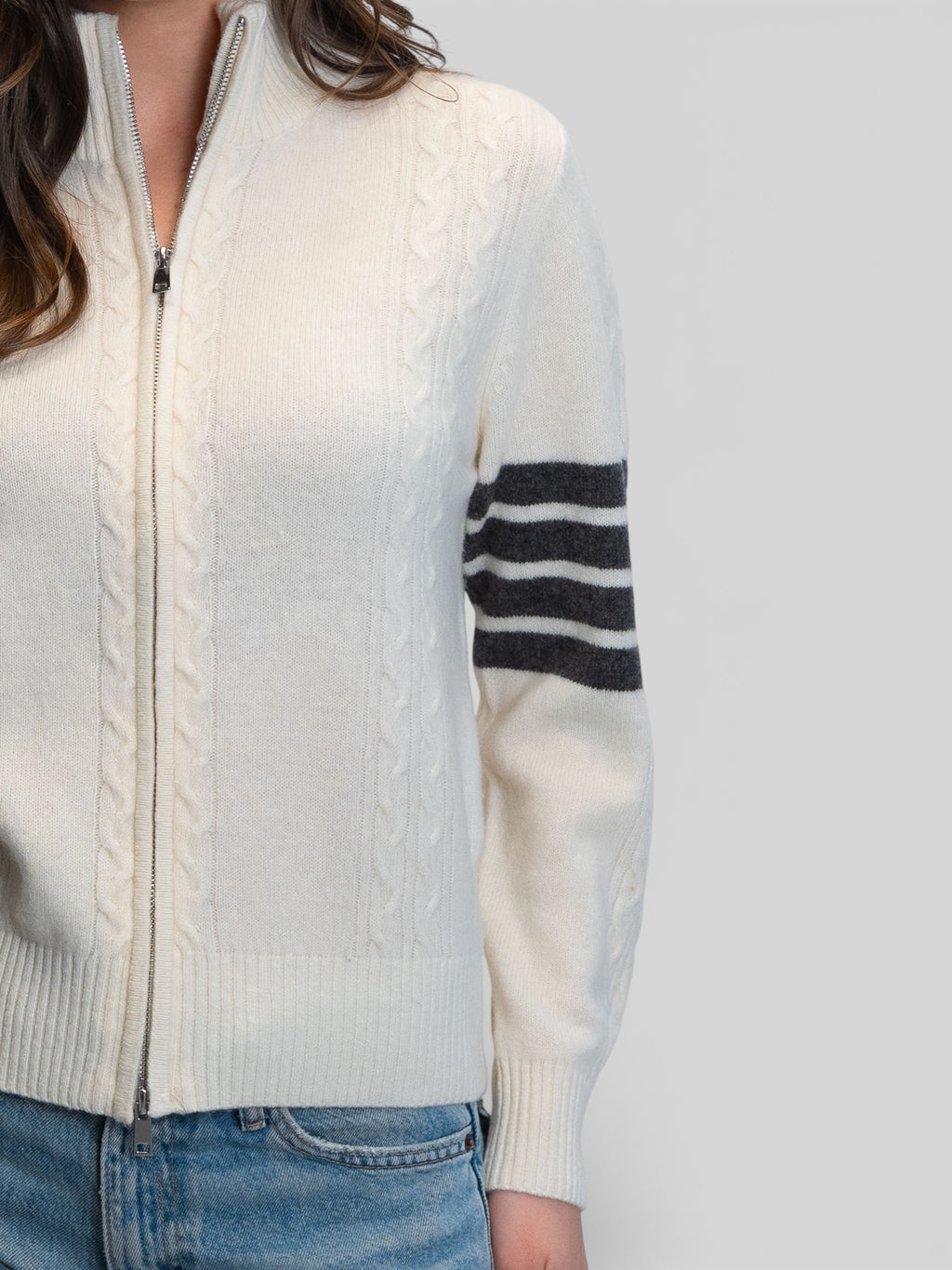 Бяла плетена жилетка с цип, плетеници и контрастни райета на ръкава
