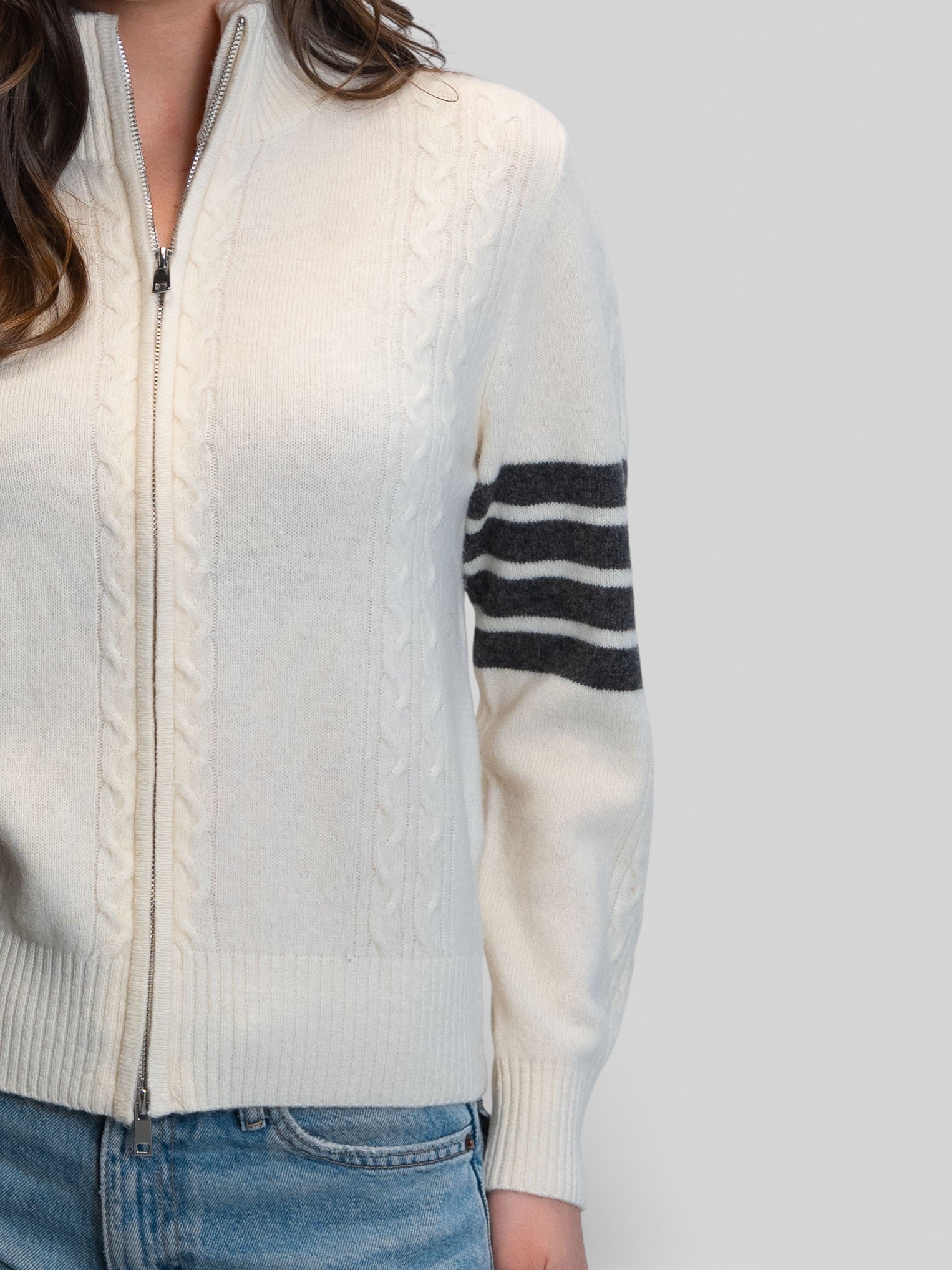 Бяла плетена жилетка с цип, плетеници и контрастни райета на ръкава