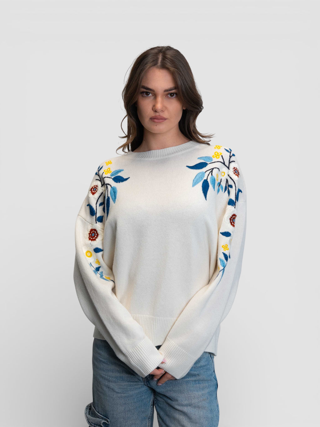 Бял пуловер с цветна бродерия на раменете и ръкавите